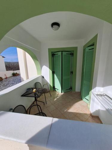 a room with green doors and a table and chairs at Naxos olive & home in Engares