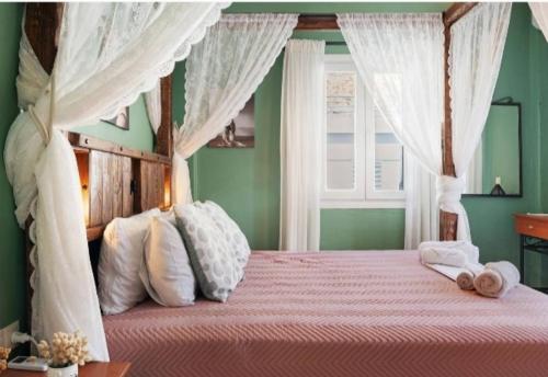 a bedroom with a canopy bed with white curtains at Panana Irida in Mérikhas