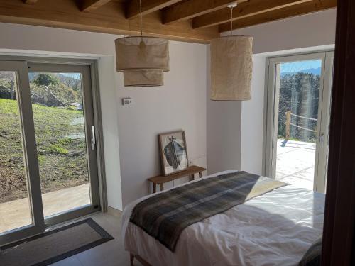 a bedroom with a bed and a large window at Casa Rural A Costa - Villa Rustica Asturias - Boal in Boal