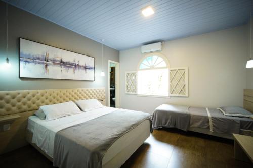 a bedroom with two beds and a window at Pousada João e Maria Gramado in Gramado