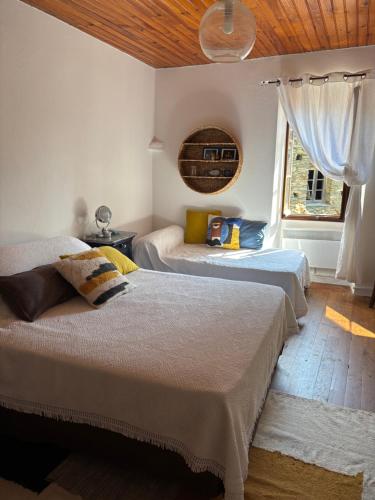 a bedroom with two beds and a wooden ceiling at Maison de village in Ortiporio