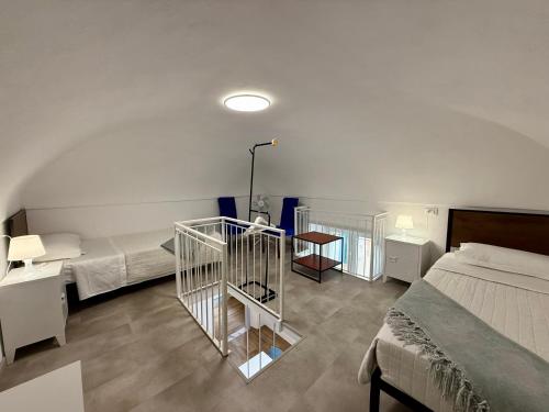 a bedroom with two beds and a staircase in it at BUDELLO Apartament in Alassio