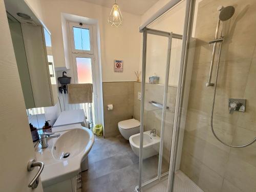 a bathroom with a shower and a sink and a toilet at BUDELLO Apartament in Alassio