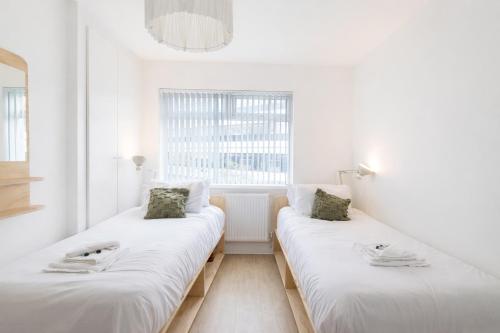 two beds in a white room with a window at Contractor Base Newport 3 Bed Van Parking Sleeps 5 in Newport