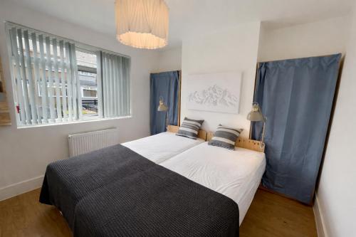 a bedroom with a large bed with blue curtains at Contractor Base Newport 3 Bed Van Parking Sleeps 5 in Newport