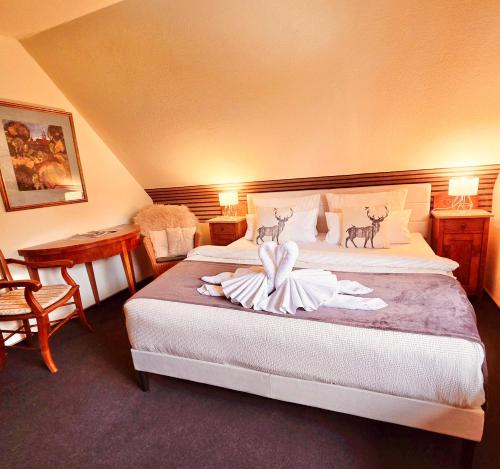 a hotel room with a bed with a towel on it at Hotel Elisabeth Ilse in Braunlage