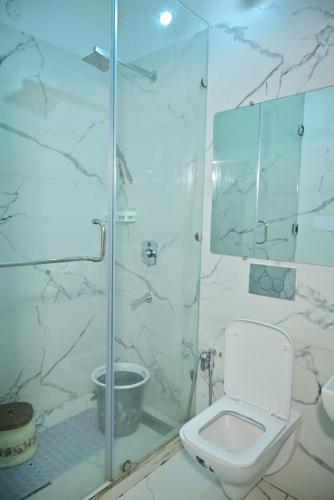 a bathroom with a toilet and a glass shower at hotel tripta ganga in Rishīkesh
