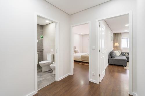 a white room with a bathroom and a bed and a toilet at Libertà Lodge Apartment - Minho's Guest in Braga