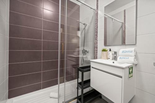 a bathroom with a shower and a white sink at Apartamento 3 Nações in Alvor