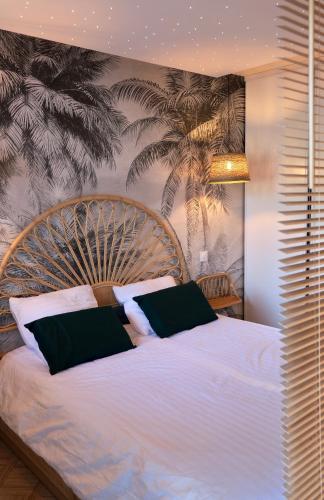 a bedroom with a large white bed with black pillows at VANILLA Lodge in Lacanau-Océan