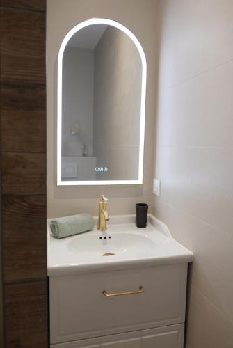 a bathroom with a white sink and a mirror at VANILLA Lodge in Lacanau-Océan