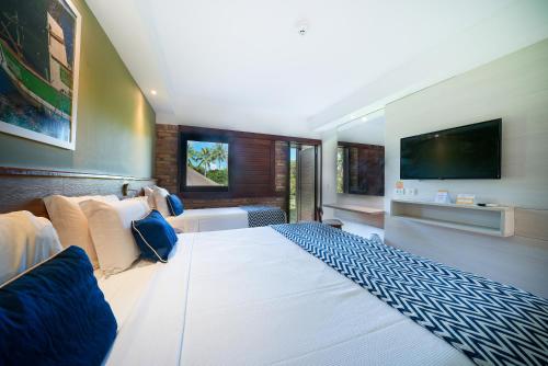 a bedroom with a large bed and a television at Salinas Maragogi All Inclusive Resort in Maragogi