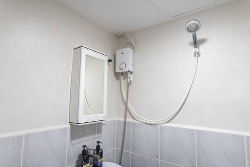 a shower in a bathroom with a sink and a mirror at Affordable Condo in Cebu with Great Views in Suba