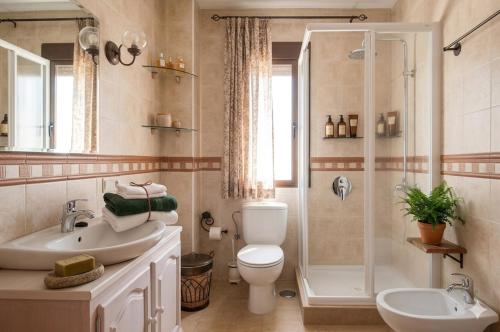 a bathroom with a shower and a toilet and a sink at Villa los Solares Casa para grupos in Corcoya