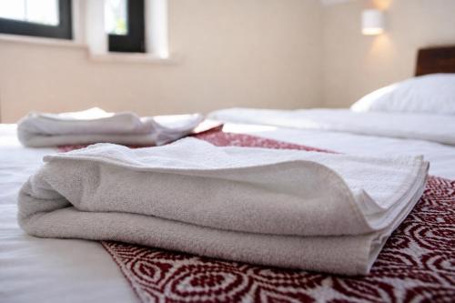two white towels are sitting on a bed at Stara Kuźnia Mazurska in Węgorzewo