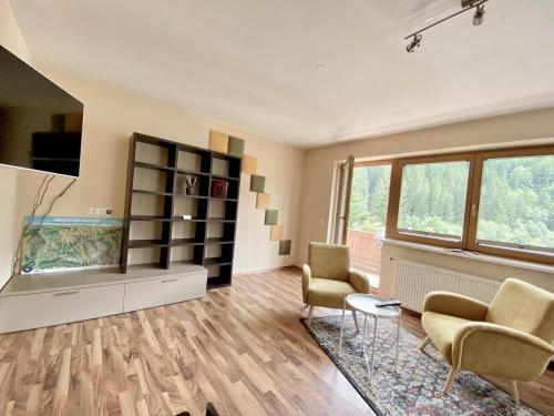a living room with two chairs and an aquarium at Hollys Ferienwohnungen in Gerlos
