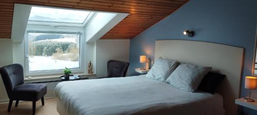 a bedroom with a large bed and a window at L'Horizon Studios & Apparts in Malmedy
