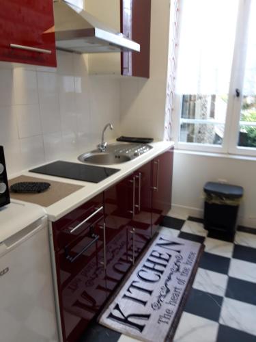 a kitchen with a sink and a kitchen rug on the floor at TINCHEBRAY Centre ville in Tinchebray