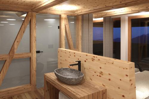 a bathroom with a stone sink on a wooden counter at Bio Aparthotel Blasla in Valle Di Casies