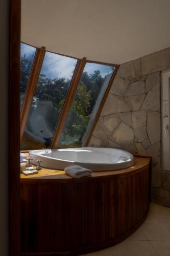 a bath tub in a bathroom with a large window at Sol Arrayan Hotel & Spa in Villa La Angostura