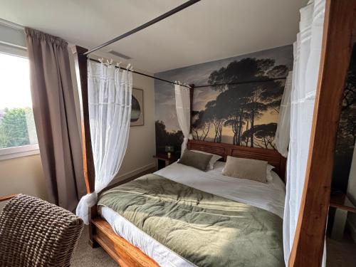 a bedroom with a canopy bed in a room at The Originals City, Hôtel La Cour Carrée, EU in Eu