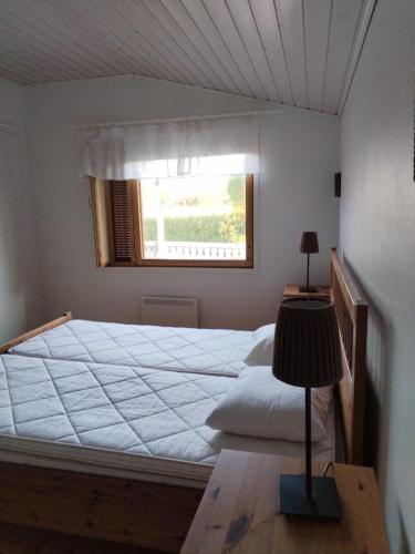 a bedroom with a large bed with a window at The red cottage in Kumlinge in Kumlinge