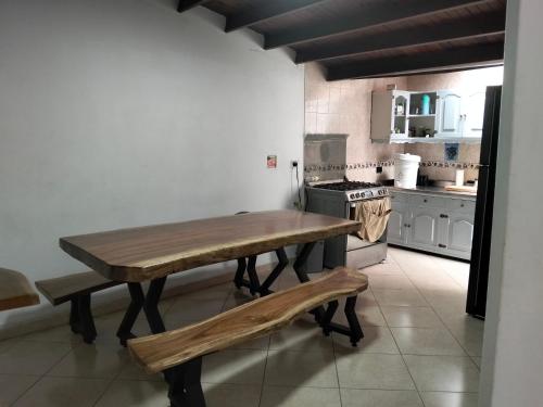 a kitchen with a wooden table and a stove at Jungle house private room in Medellín