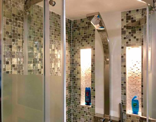 a bathroom with a shower with a glass door at The Beach Barn in Cardiff