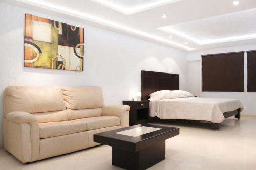 a living room with a couch and a bed at Hotel Acámbaro Plaza in Acámbaro