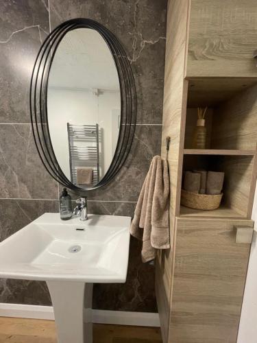 a bathroom with a sink and a mirror at The Lodge@Tyddyn Ucha in Caernarfon