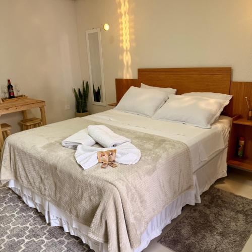a bedroom with a bed with two towels and two dolls at Suíte - Top Country Ranch in Boituva