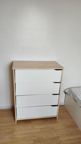 a white dresser with a wooden top next to a bed at Chambre Deluxe avec Salle de bain et clim in Bourges
