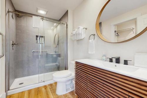 a bathroom with a shower and a toilet and a mirror at Saltbox 12F in White River Junction