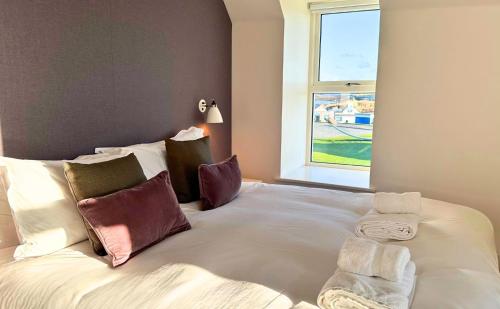 a large white bed in a room with a window at Northstar - 4 Bed Luxury Apartment by Together Travel in John O Groats