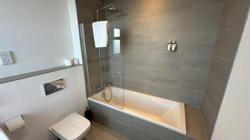 a bathroom with a shower with a tub and a toilet at Northstar - 4 Bed Luxury Apartment by Together Travel in John O Groats