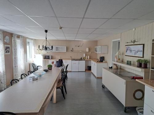 a large kitchen with a long table and chairs at The Sisters Landeskogen in Grendi