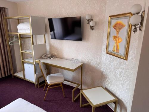 ein Hotelzimmer mit Schreibtisch und Bett in der Unterkunft Hotel Dafi in Plowdiw