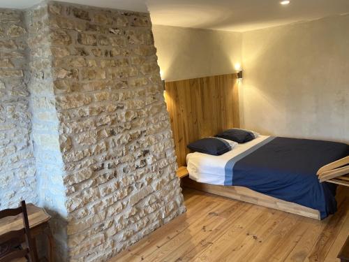 a bedroom with a bed and a brick wall at Au point du jour Ch1 in Récourt-le-Creux