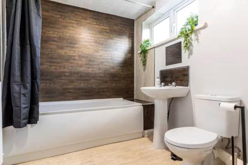 a bathroom with a tub and a toilet and a sink at Modern 3BR Durham Stay for Work Trips in Brandon