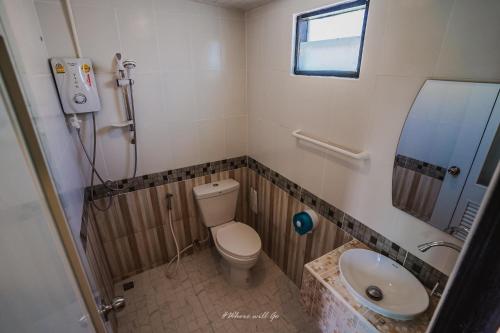 a small bathroom with a toilet and a sink at Hun Resort in Khanom