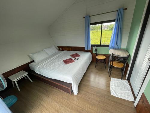 a small bedroom with a bed and a window at Hun Resort in Khanom