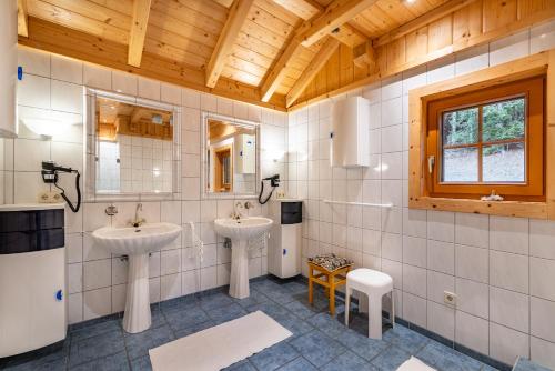 a bathroom with two sinks and a wooden ceiling at Haus Karin in Heiligenblut