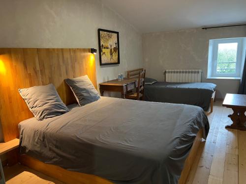 a bedroom with two beds and a table and a window at au point du jour Ch3 in Récourt-le-Creux