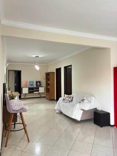 a bedroom with a bed and a living room at Econômica Joinville Hostel e Pousada in Joinville