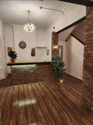 an empty room with a brick wall and a chandelier at The Limes Hotel in Market Rasen