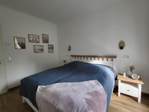 a bedroom with a blue bed and a table at Ferienwohnung Zum Adlernest in Hellenthal