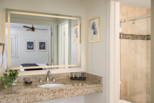 a bathroom with a sink and a large mirror at Indigo Inn in Charleston