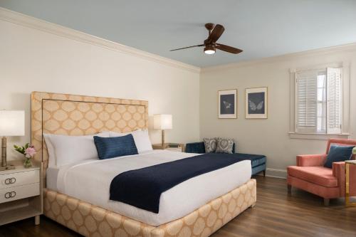 a bedroom with a large bed and a chair at Indigo Inn in Charleston