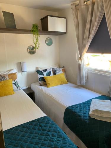 a bedroom with two beds and a window at Sunset Lagoon House in Lagoa