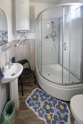 a bathroom with a shower and a toilet and a sink at Ádám nyaralóház in Balatonalmádi